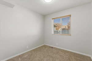 Carpeted empty room with baseboards