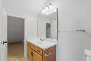 Bathroom with vanity and lofted ceiling