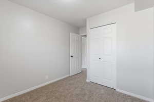 Unfurnished bedroom featuring carpet flooring and a closet