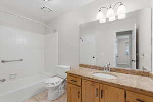 Bathroom with light tile patterned floors, vanity, and shower / tub combination