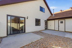 Back of house featuring a patio and roof with shingles
