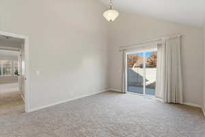 Spare room featuring high vaulted ceiling and light carpet