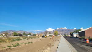 View of asphalt street featuring a mountain view and curbs