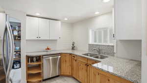 Kitchen featuring light stone counters, appliances with stainless steel finishes, recessed lighting, white cabinets, and light tile patterned flooring