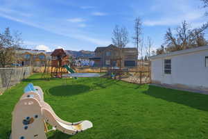 View of yard with a playground, a trampoline, and a residential view
