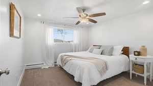 Carpeted bedroom with a ceiling fan, recessed lighting, and a baseboard heating unit