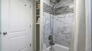 Bathroom featuring shower / tub combo with curtain