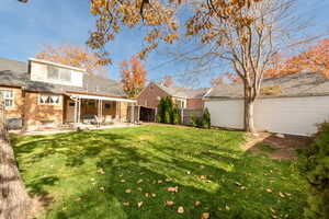 Back of house featuring brick siding, a patio area, and a shingled roof