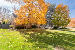 View of side of property featuring a yard, brick siding, and board and batten siding