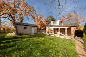 Rear view of house with brick siding, a fenced backyard, a patio area, and an outdoor structure