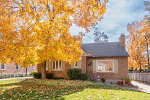 View of front of home featuring brick siding and a chimney