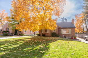 View of front of home featuring a chimney and brick siding