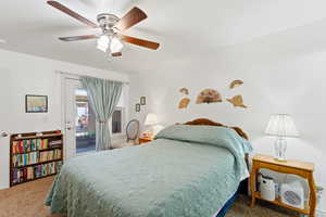 Carpeted bedroom with access to outside and ceiling fan