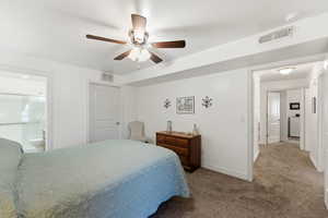 Carpeted bedroom with a ceiling fan and ensuite bathroom