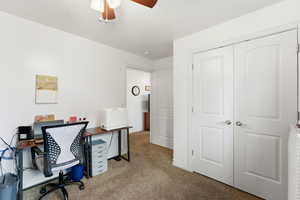 Office area with light carpet and a ceiling fan