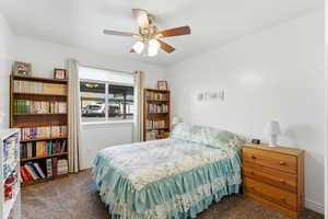 Bedroom featuring dark colored carpet and a ceiling fan