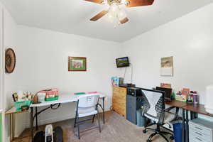 Office area with light carpet and a ceiling fan