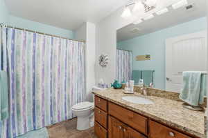 Full bath with a shower with curtain and vanity