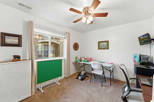 Office space featuring light colored carpet and a ceiling fan