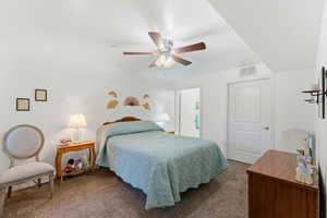 Carpeted bedroom featuring a ceiling fan