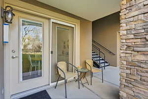 Doorway to property with stone siding and a patio area