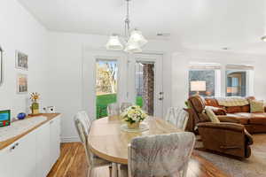 Dining space featuring healthy amount of natural light, light wood-style flooring, and a chandelier