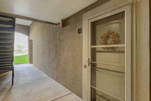 Entrance to property featuring stucco siding and a patio area