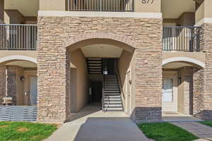 Doorway to property with stone siding and stucco siding