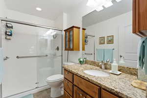 Full bathroom with vanity, a shower stall, a skylight, recessed lighting, and light tile patterned flooring