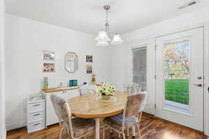 Dining room with wood finished floors and a chandelier