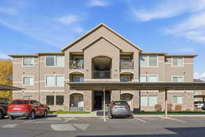 View of building exterior featuring covered parking