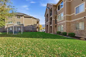 View of home's community featuring a lawn, a pergola, and a patio