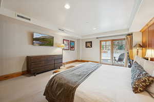 Carpeted bedroom featuring recessed lighting, access to outside, and a raised ceiling