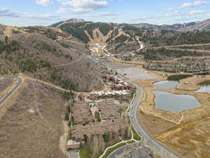 Aerial view of property and surrounding area featuring a water and mountain view and nearby suburban area