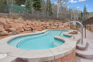 View of swimming pool with a patio area, an outdoor hot tub, and a pool