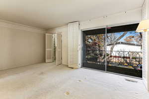 Unfurnished bedroom with ornamental molding, carpet floors, access to exterior, and wallpapered walls