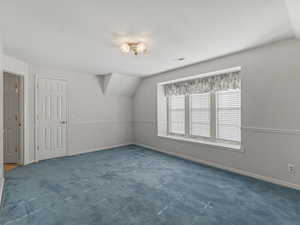 Bonus room with carpet flooring and baseboards