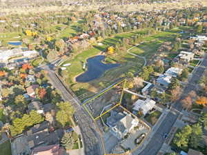 Aerial perspective of suburban area featuring property boundaries highlighted, a large body of water, and a golf course
