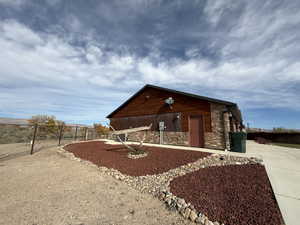 View of side of house featuring stone siding and concrete driveway