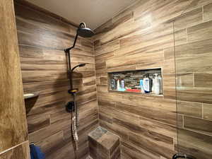 Full bathroom featuring tiled shower and a textured ceiling