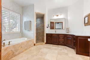 Bathroom with a garden tub, double vanity, a shower stall, and light tile patterned floors