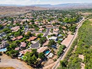 Aerial perspective of suburban area featuring a mountain backdrop and a pool