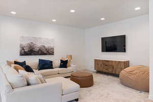 Carpeted living room with recessed lighting and baseboards