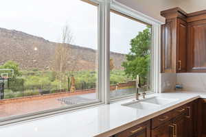 Kitchen featuring light stone counters, dark brown cabinets, and a mountain view