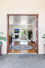 Entryway with a glass covered fireplace and brick floors