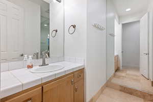 Bathroom with vanity, light tile patterned flooring, and recessed lighting