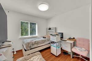 Bedroom featuring light wood-type flooring and an office area