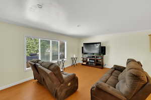 Living room with crown molding and light wood-type flooring