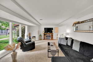 Carpeted living room featuring a glass covered fireplace