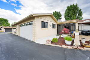 View of front of house featuring a sunroom, a garage, and brick siding